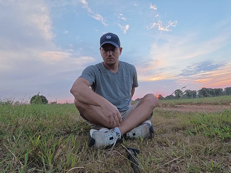 Don sitting in a field at sunrise, breathing